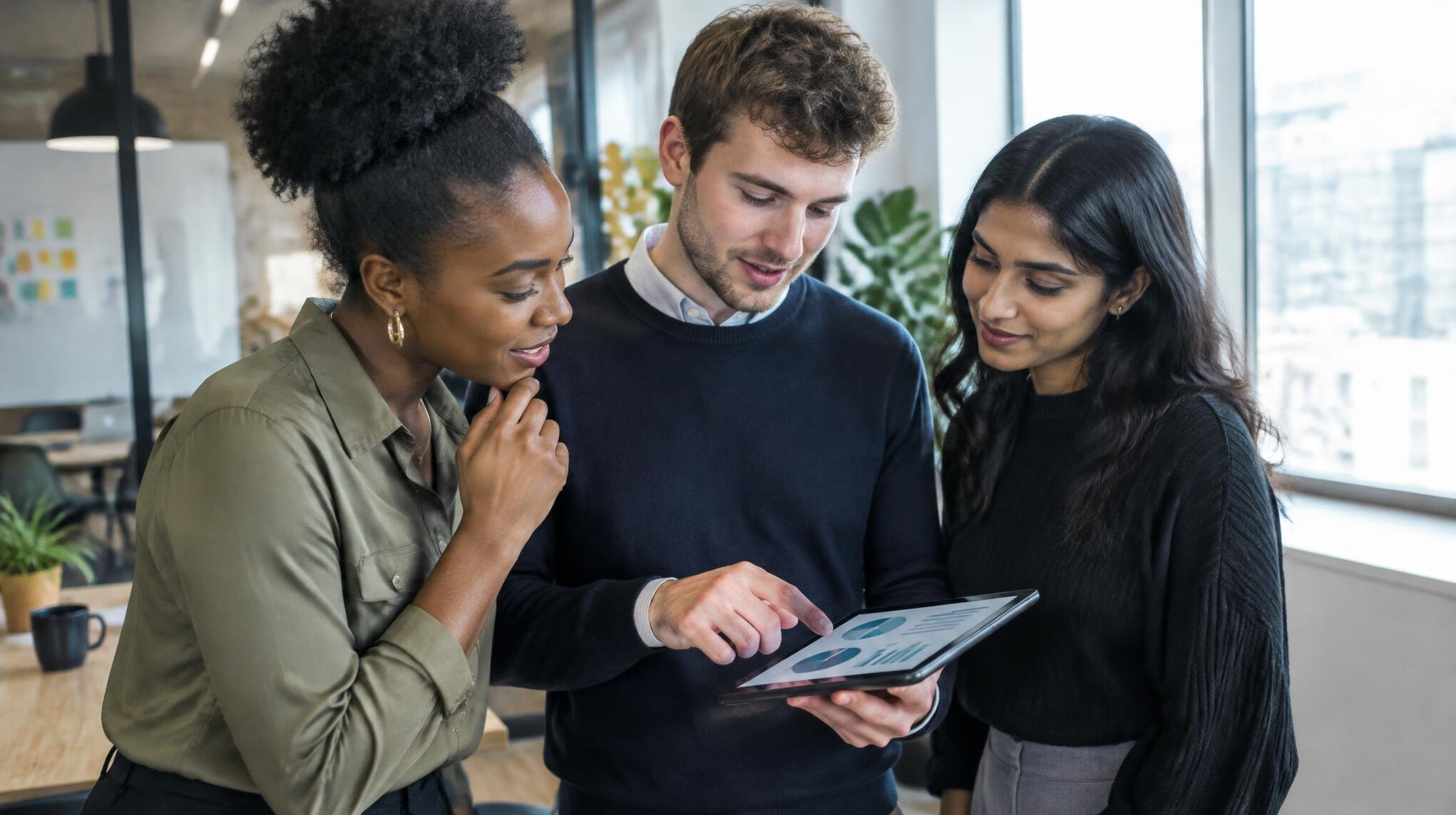 Group of diverse young people discussing survey results on a tablet